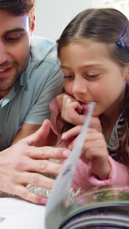 Father-and-daughter-reading-book-in-the-living-room