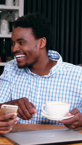 Man-and-woman-interacting-with-each-other-while-having-cup-of-coffee