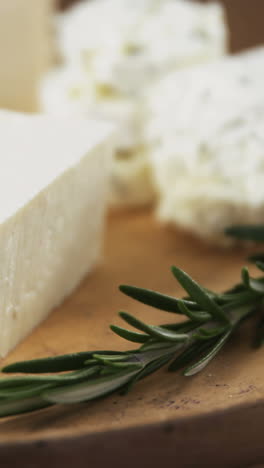 Slices-of-cheese-on-wooden-board