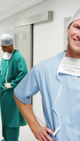 Portrait-of-male-surgeon-standing-with-hands-on-hips