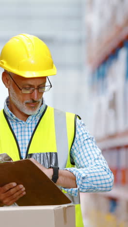 Warehouse-worker-writing-on-clipboard