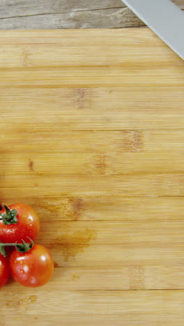 Tomates-Cherry-Y-Cuchillo-De-Cocina-Sobre-Una-Tabla-De-Cortar