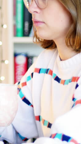 Mujer-Usando-Una-Computadora-Portátil-Mientras-Toma-Una-Taza-De-Café