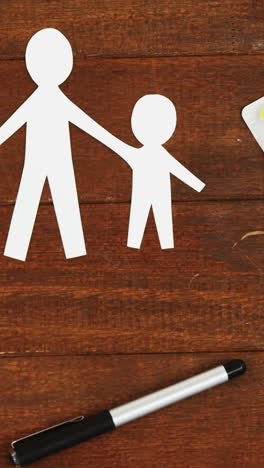 Close-up-of-a-paper-cut-out-of-a-family-with-tablet-and-pen