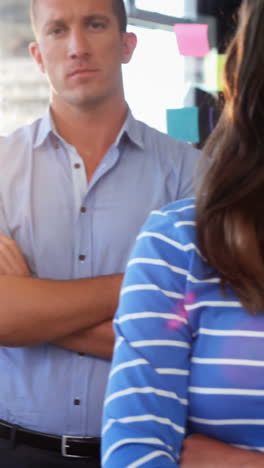 Business-executives-standing-with-arms-crossed-in-office