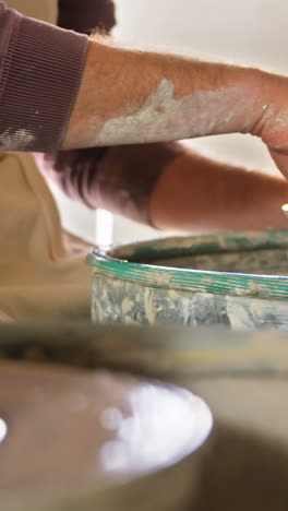 Mid-section-of-male-and-female-potter-working-together