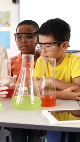 School-kids-doing-chemical-experiment-in-classroom