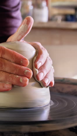 Mid-section-of-potter-making-pot