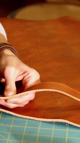 Close-up-of-craftswoman-cutting-leather