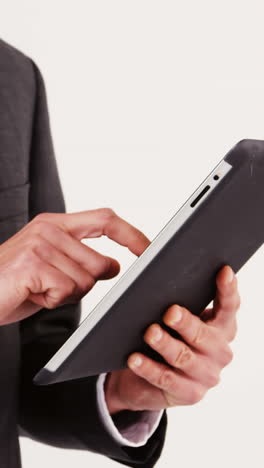 Mid-section-of-businessman-using-digital-tablet