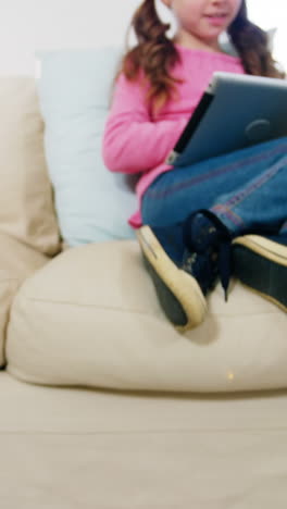 Girl-using-digital-tablet-while-father-cleaning-a-carpet-with-a-vacuum-cleaner