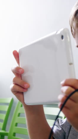 Boy-using-digital-tablet-in-hospital-corridor