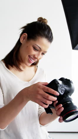 Photographer-looking-at-photos-on-digital-camera