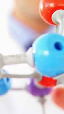 Close-up-of-scientist-holding-molecule-model