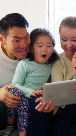 Happy-family-using-digital-tablet-in-living-room