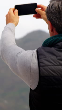 Reifer-Mann,-Der-Die-Aussicht-Vom-Mobiltelefon-Aus-Fotografiert