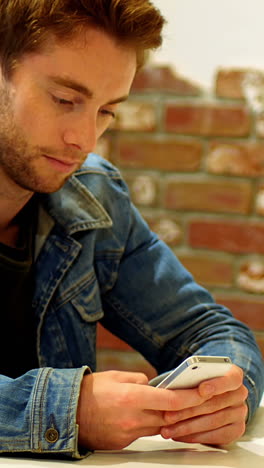 Man-using-mobile-phone-at-table