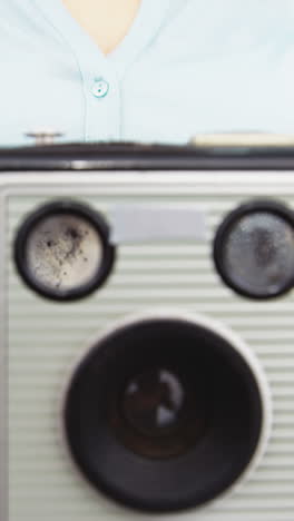 Close-up-of-photographer-taking-photo-with-vintage-camera