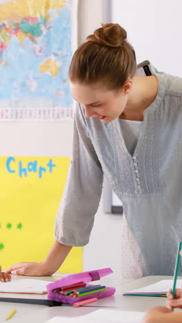 Teacher-helping-kids-with-their-homework-in-classroom