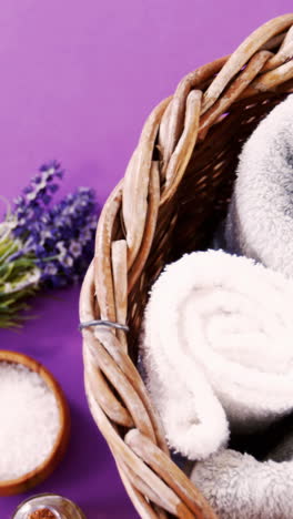 Sea-salt-in-wooden-bowl,-towel,-oil,-candle-and-flowers