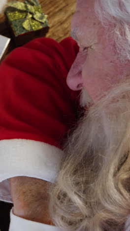 Santa-claus-sleeping-at-desk-while-writing-a-letter-with-a-quill