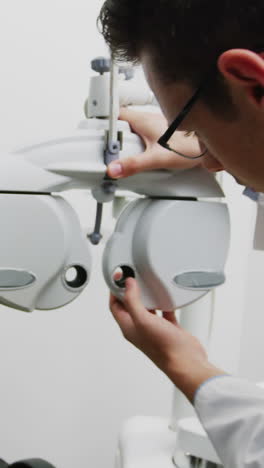 Smiling-optometrist-adjusting-phoropter