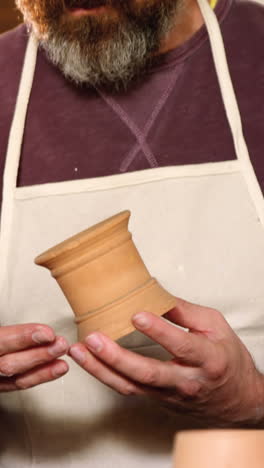 Male-and-female-potter-interacting-while-examining-a-pot