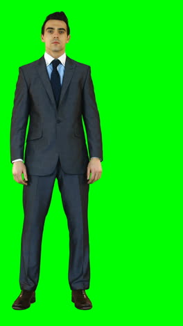 Businessman-standing-against-green-background