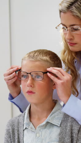 Optometrista-Femenina-Recetando-Gafas-A-Un-Paciente-Joven