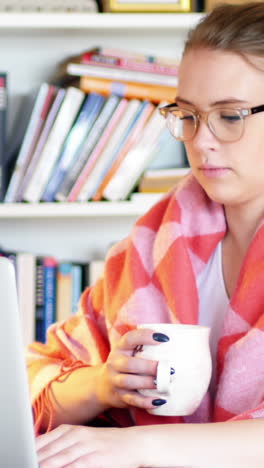 Mujer-Usando-Una-Computadora-Portátil-Mientras-Toma-Una-Taza-De-Café