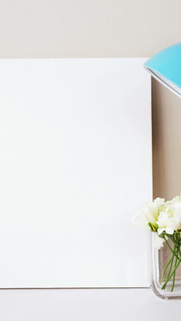 Stack-of-books,-blank-board,-flower-vase,-cup-of-tea-and-table-lamp