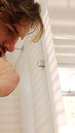 Man-brushing-his-teeth-in-bathroom