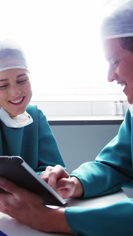 Doctor-and-colleague-discussing-over-digital-tablet