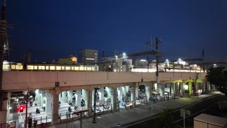 Escena-Nocturna-De-La-Ciudad-De-Hamamatsu-Con-Trenes-Pasando-Y-Estacionamiento-De-Bicicletas