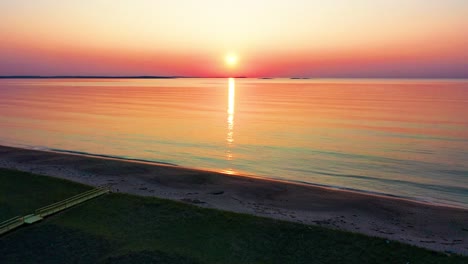 Wooden-Walking-Path-Leads-to-Colorful-Ocean-Sunset-on-Beach