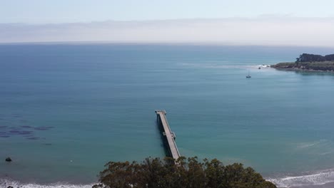 Aerial-descending-close-up-shot-of-the-William-Randolph-Hearst-Memorial-Beach-Pier-in-Old-San-Simeon-Village,-California