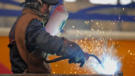 close-up-shot-lots-of-sparks-in-the-factory,-Welder-at-work-in-protective-mask-welding-metal-construction-industry-at-industrial-production