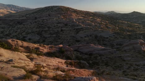 Vista-Aérea-Baja-Sobre-Rocas-Del-Desierto-En-El-Parque-Natural-Vasquez,-Puesta-De-Sol-En-Estados-Unidos