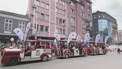 Los-Pasajeros-Viajan-En-El-Tren-Turístico-De-La-Ciudad-En-La-Procesión-Del-Festival-De-Las-Rosas.