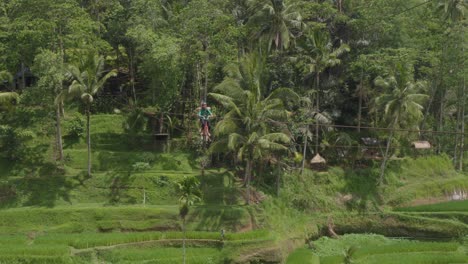 Una-Pareja-Disfruta-De-Un-Emocionante-Paseo-En-Una-Bicicleta-Tándem-Suspendida-Sobre-Las-Exuberantes-Terrazas-De-Arroz-De-Tegallalang,-Bali,-Indonesia.