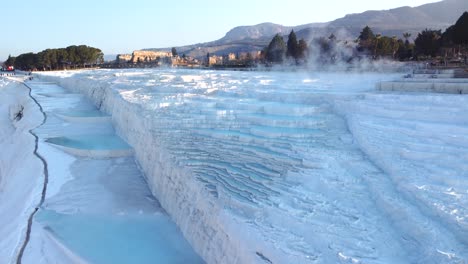 Steamy-hot-springs,-blue-mineral-waters,-forming-travertine-limestone-mineral-deposit-formations