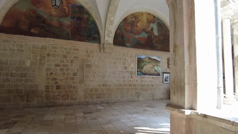 Walking-through-the-hallways-and-gallery-of-the-Franciscan-Church-and-Monastery-in-Dubrovnik,-Croatia,-exploring-the-concept-of-spiritual-serenity-and-historical-reverence