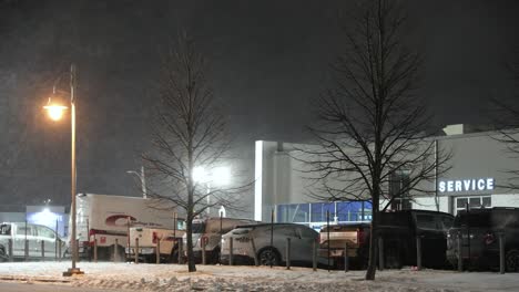 Outside-car-service-repair-shop-during-snow-storm-at-night-Saint-Jean-sur-Richelieu,-Québec,-Canada