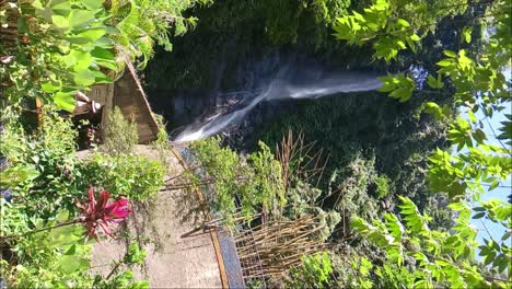 Tourist-in-front-of-Tammasapi-Waterfall-in-Mamuju,-West-Sulawesi,-Indonesia_vertical-view