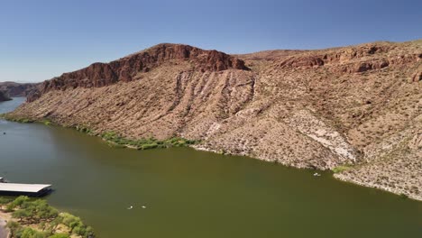 Canyon-Lake-in-Tortilla-Flat-Az-near-Phoenix-panning-right-aerial-drone-view-of-the-mountains,-water,-cars,-and-boats