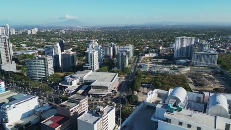 Picturesque-view-of-Philippine-cityscape-with-bustling-streets-and-modern-buildings,-and-greenery-in-background--aerial-dolly-shot