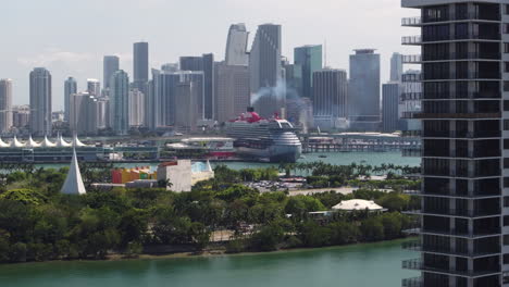 Aerial-view-approaching-a-cruise-liner-in-front-of-downtown-Miami,-Florida,-USA