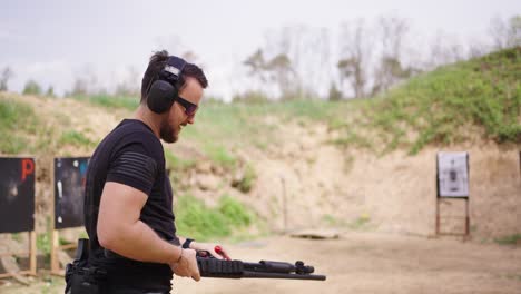 Olesko-shooting-range-instructor-load-shell-ammunition-into-shotgun-barrel