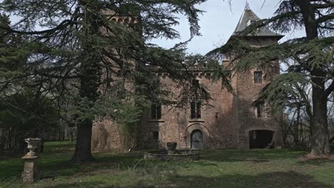 Travelling-shot-of-the-front-of-Perafita-Castle-seen-through-the-trees-in-Catalonia,-Spain