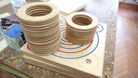 Wooden-rings,-painted-boards-ready-for-assembly-into-game-in-small-game-factory